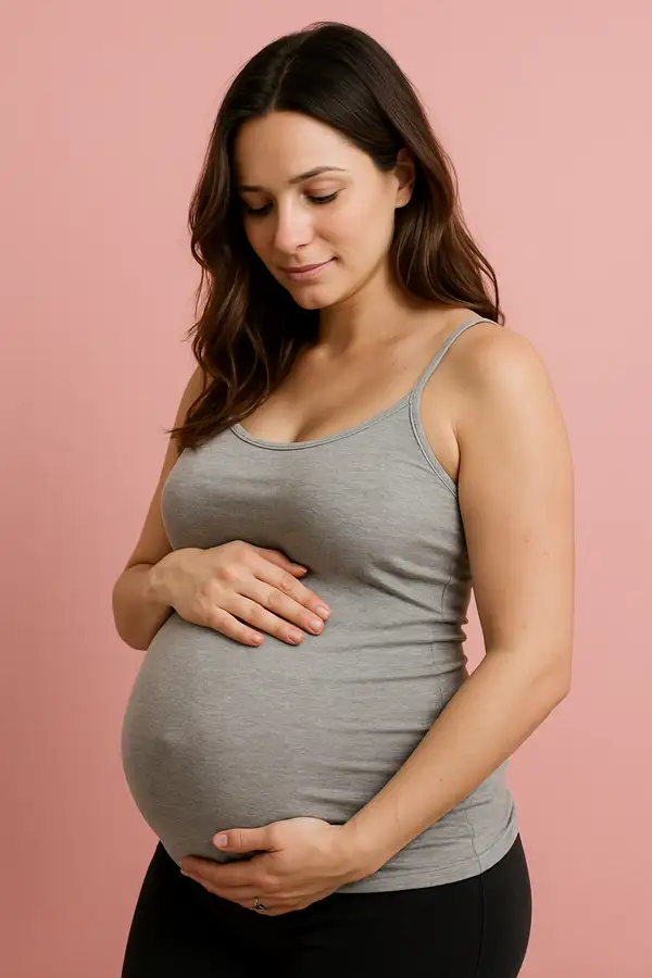 “Pregnant woman gently holding her belly during antenatal pregnancy care”